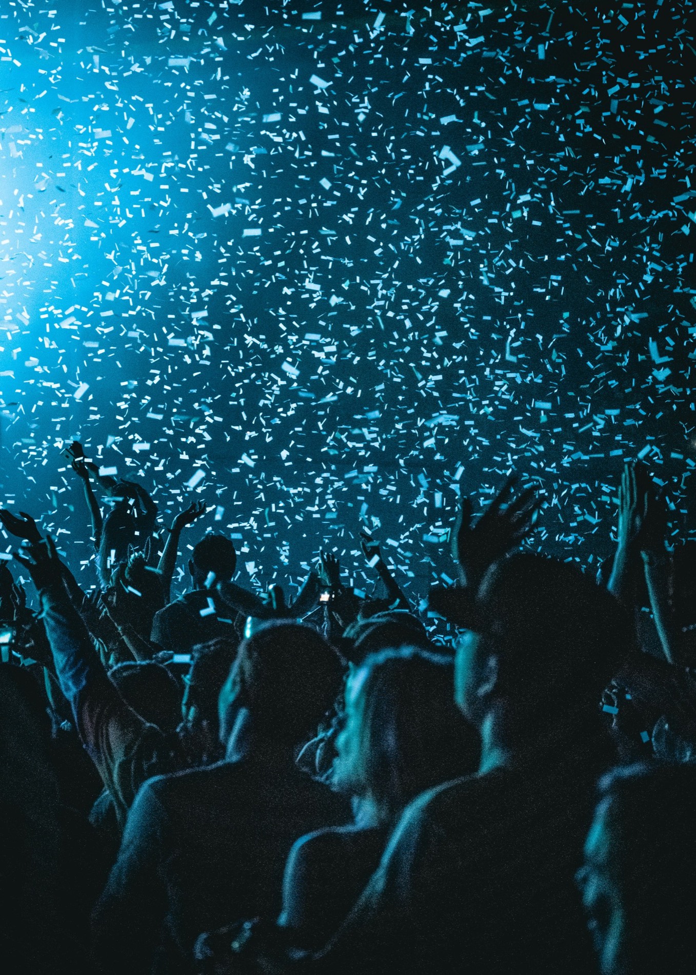 A packed crowd under stage lighting